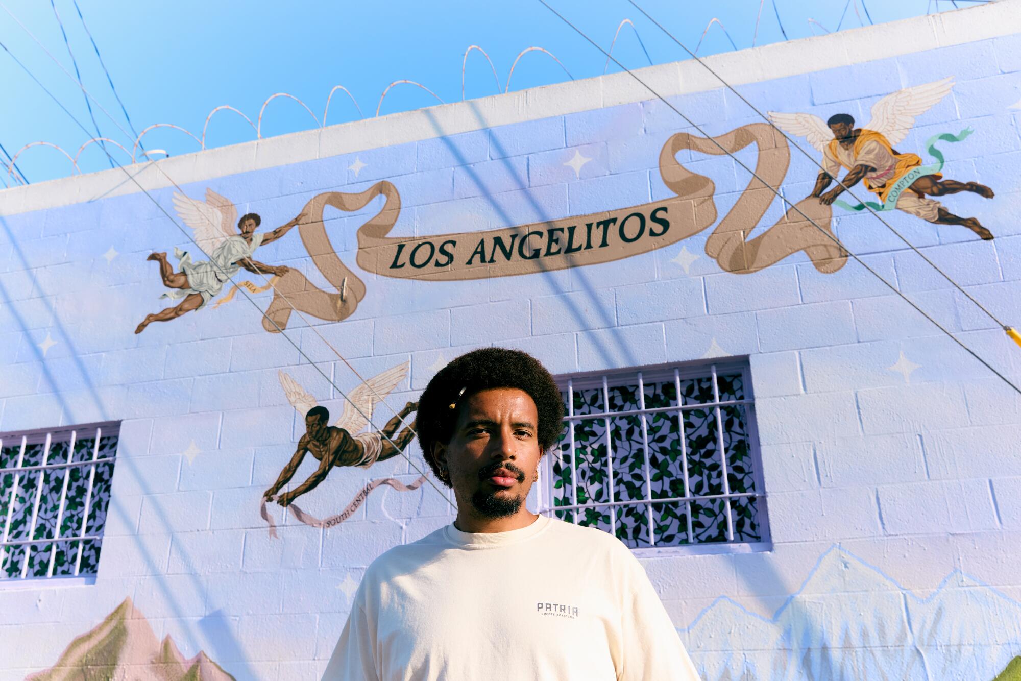 Artist Anthony Pittman with the first mural of his "Los Angelitos" series. Jennelle Fong / For The Times.