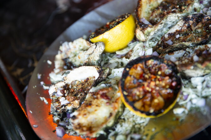 Oysters on a tray with charred lemons.