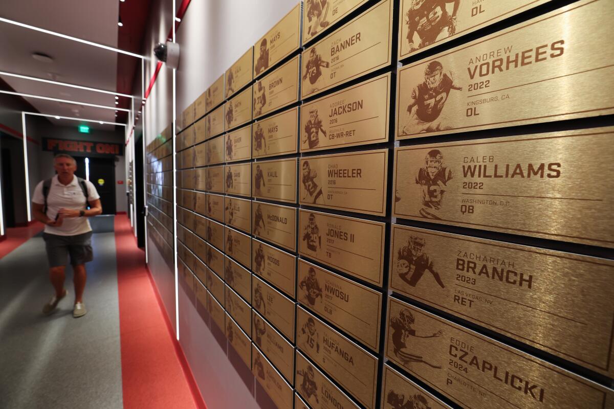 Bronze plaques of previous USC players adorn the wall of the Mark and Mary Stevens Trojan Legacy Wall at the USC Bloom Football Performance Center.
