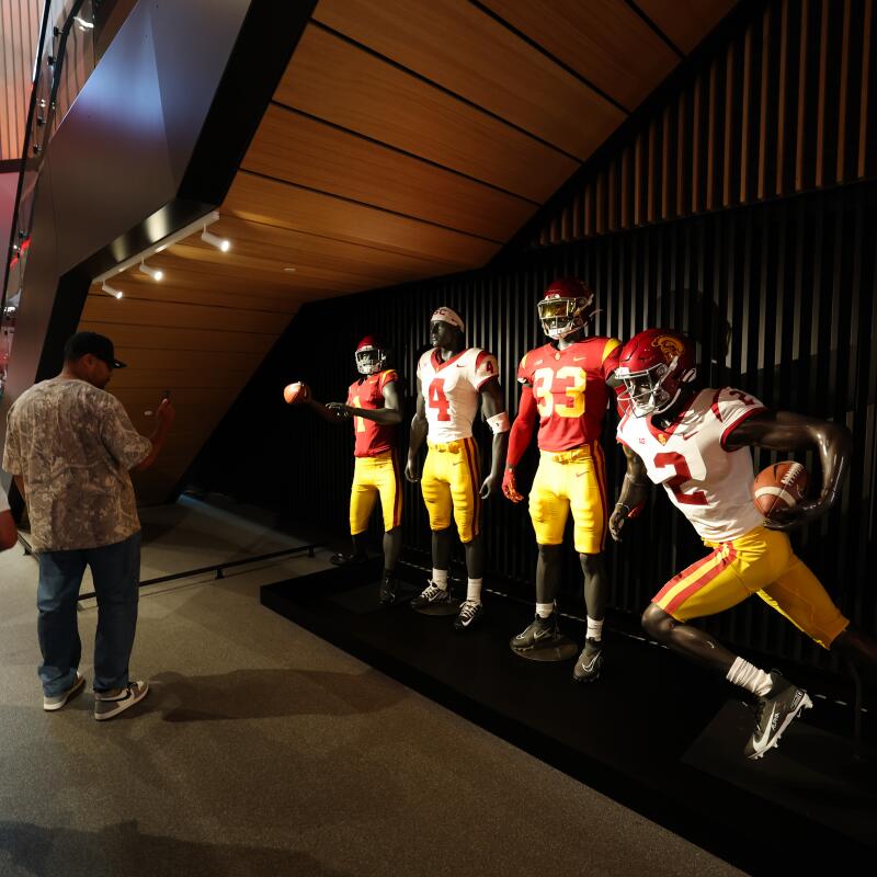 Mannequins on display with USC football uniforms outside of the on-site cafeteria at the Bloom Football Performance Center.