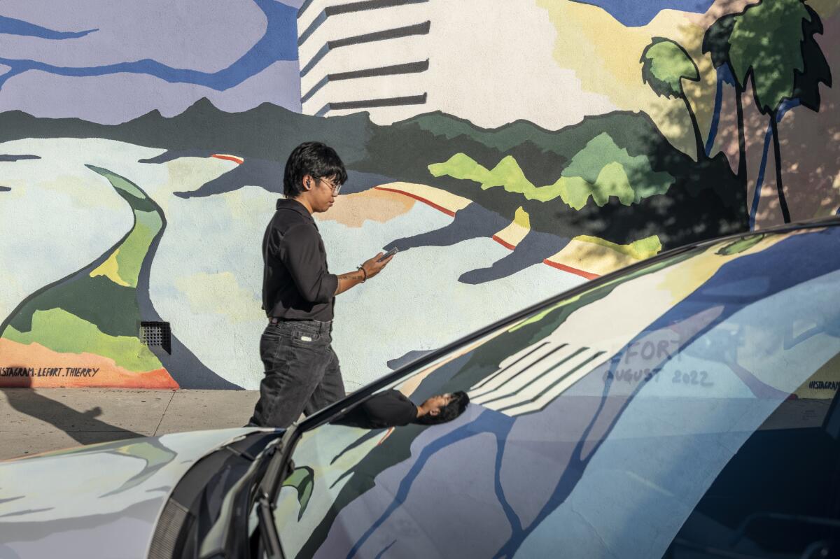 A man walks past a mural on Orange Grove Avenue off of San Fernando Boulevard.