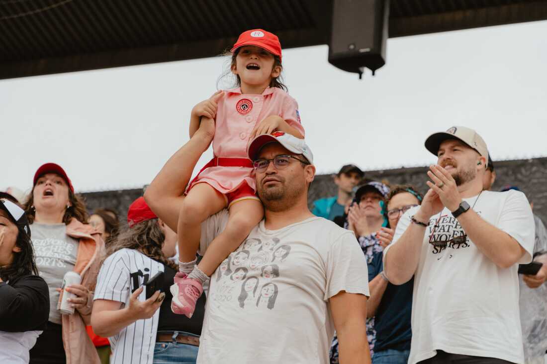 A young fan dons a Rockford Peaches uniform - a nod to the All-American Girls Professional League and inspiration for the Hollywood blockbuster "A League of Their Own" - at Opening Day of the Women's Pro Baseball League. Springfield, IL, August 1, 2026.