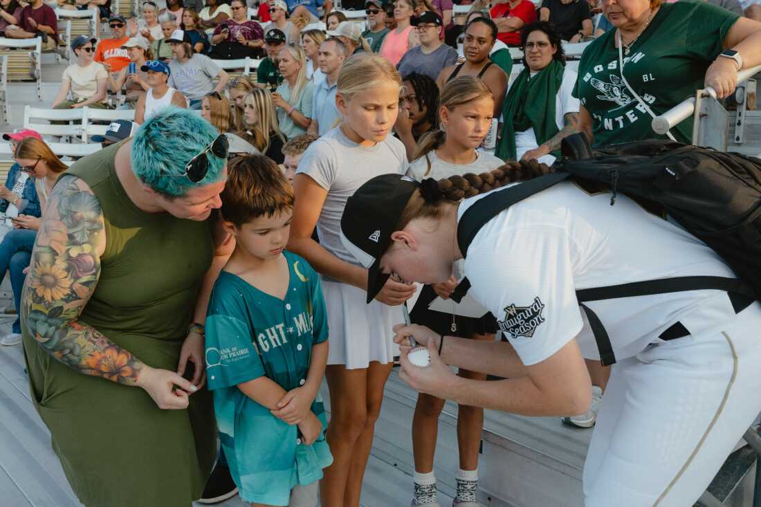 LA Queens player signs autographs for fans in the crowd of Robin Roberts Stadium during the San Francisco Firebells-Boston Hunters game of the Women's Pro Baseball League. Springfield
