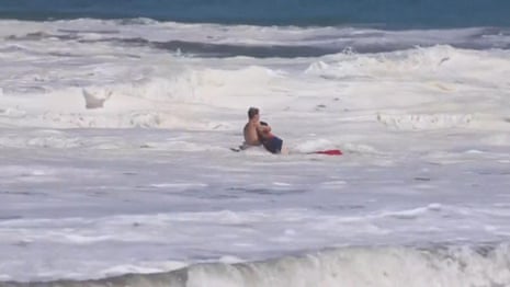 Teen lifeguard struggles to save boy from massive waves in California - video