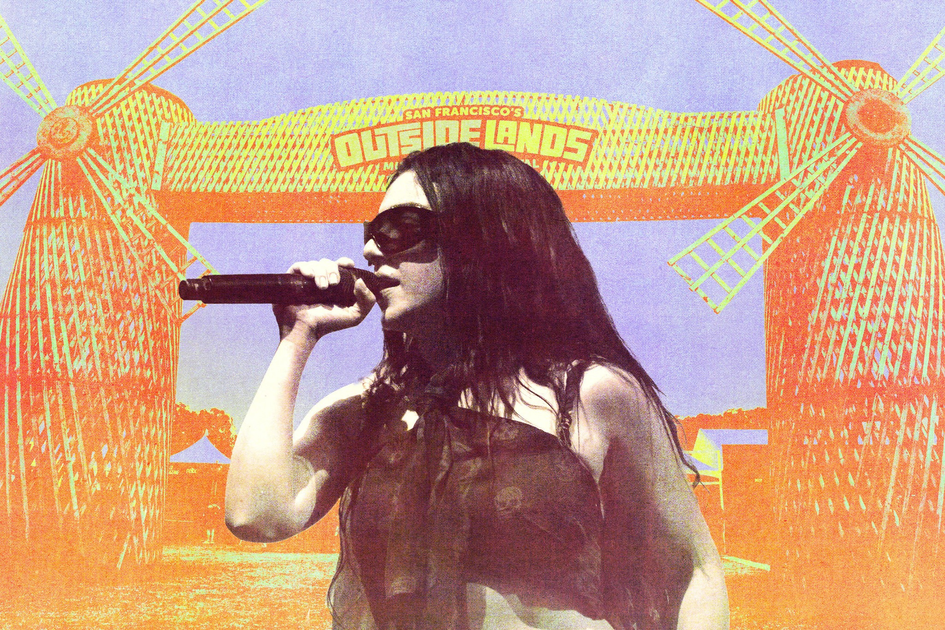 A woman with long dark hair and sunglasses sings into a microphone in front of a colorful festival entrance with two windmill structures and a sign reading "Outside Lands."