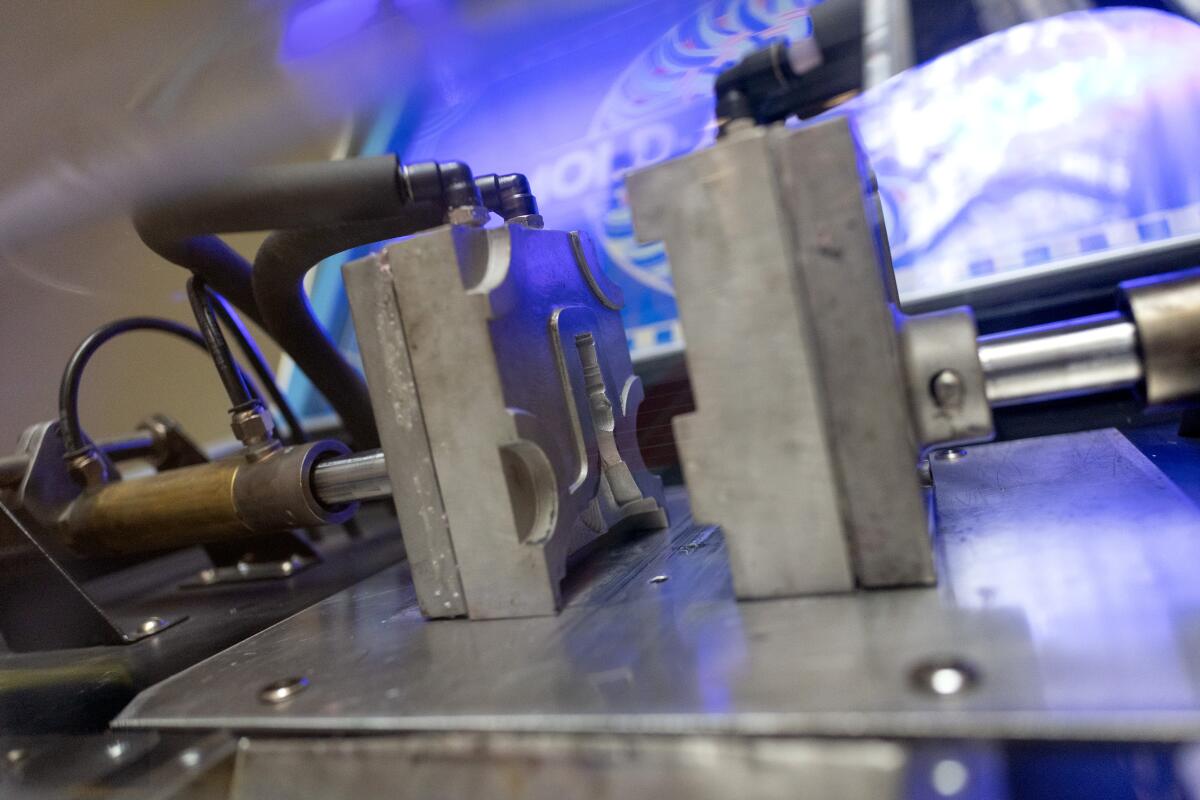 A metal two-sided mold driven by pistons inside the Mold-a-Central machine.