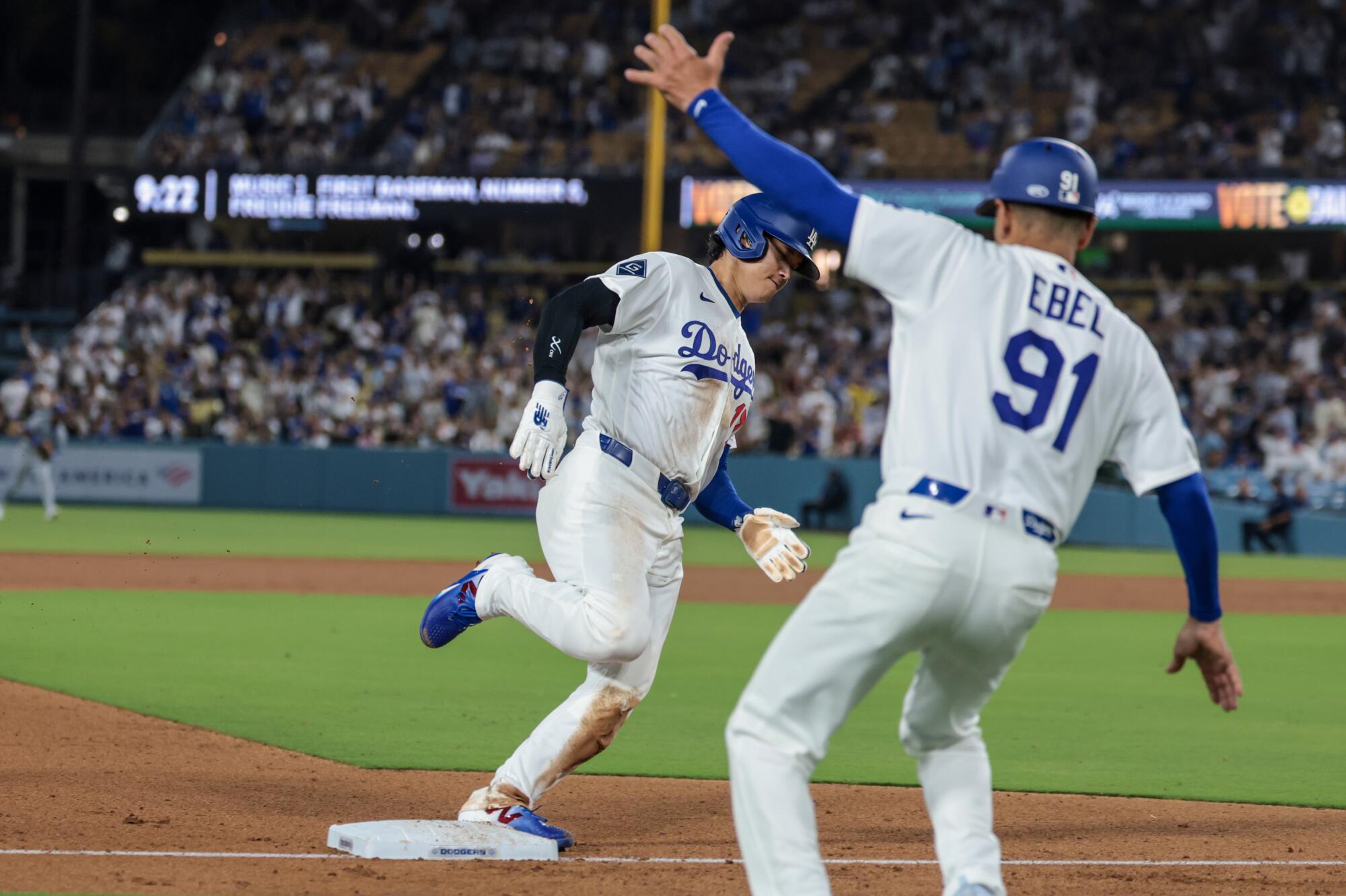 Dodgers third base coach Dino Ebel waves home Shohei Ohtani on a single by Freddie Freeman.