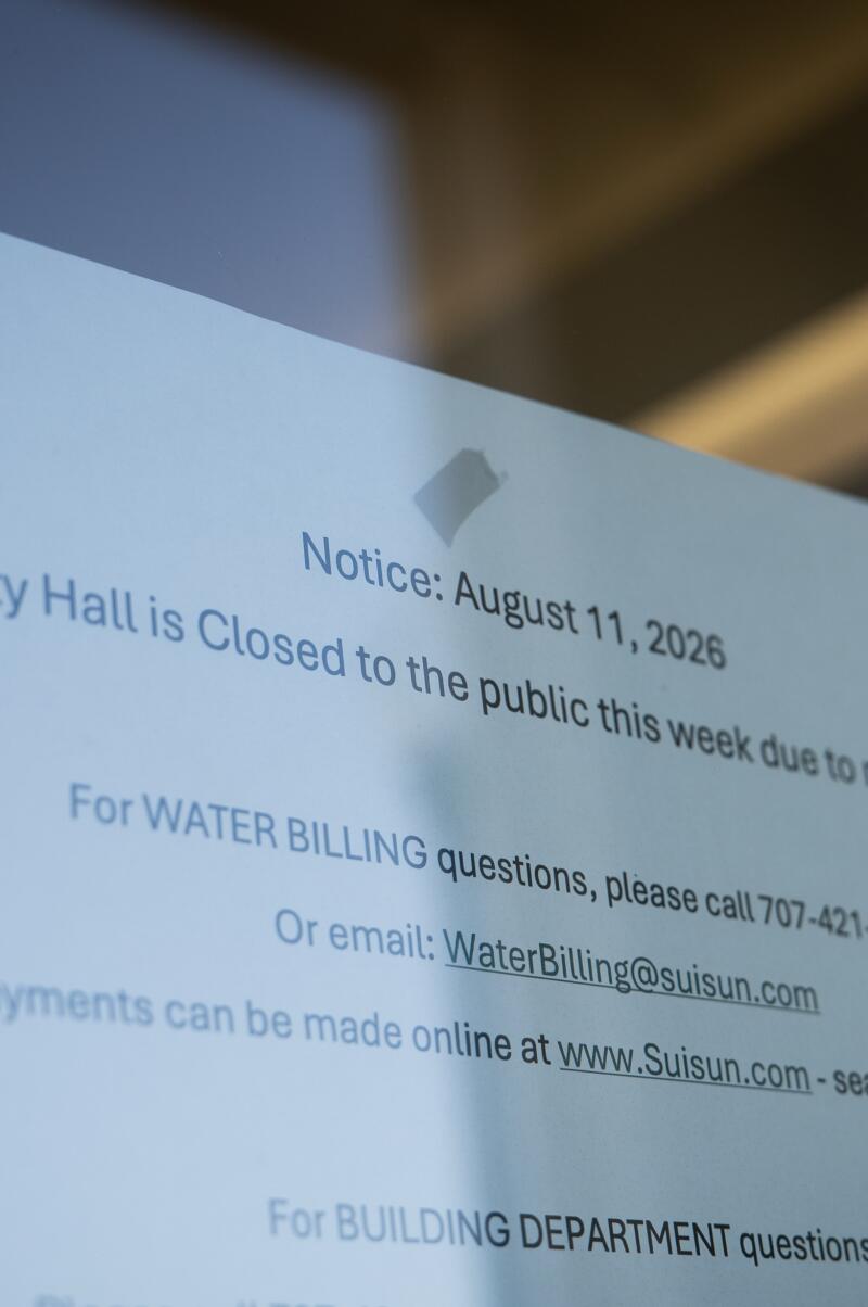 A printout dated Aug. 11 is taped to glass, reading: Suisun City Hall is Closed to the public this week due to network issues