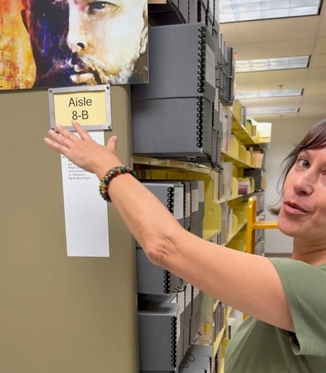Archivist Patrice Prestinary points to a painted portrait of Philp K. Dick.
