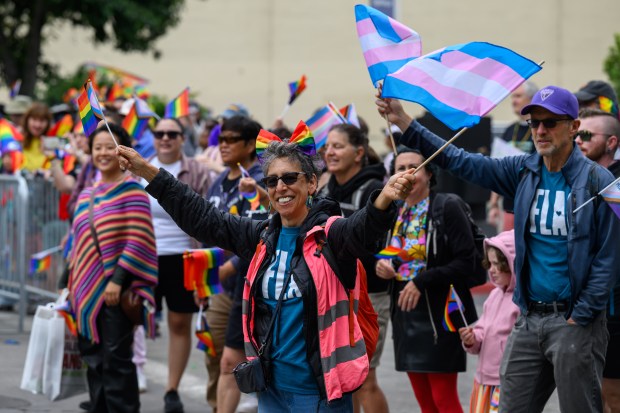 Parade spectators wave flags during the Oakland Pride Parade in Oakland, Calif., on Sunday, Aug. 16, 2026. (Jose Carlos Fajardo/Bay Area News Group)