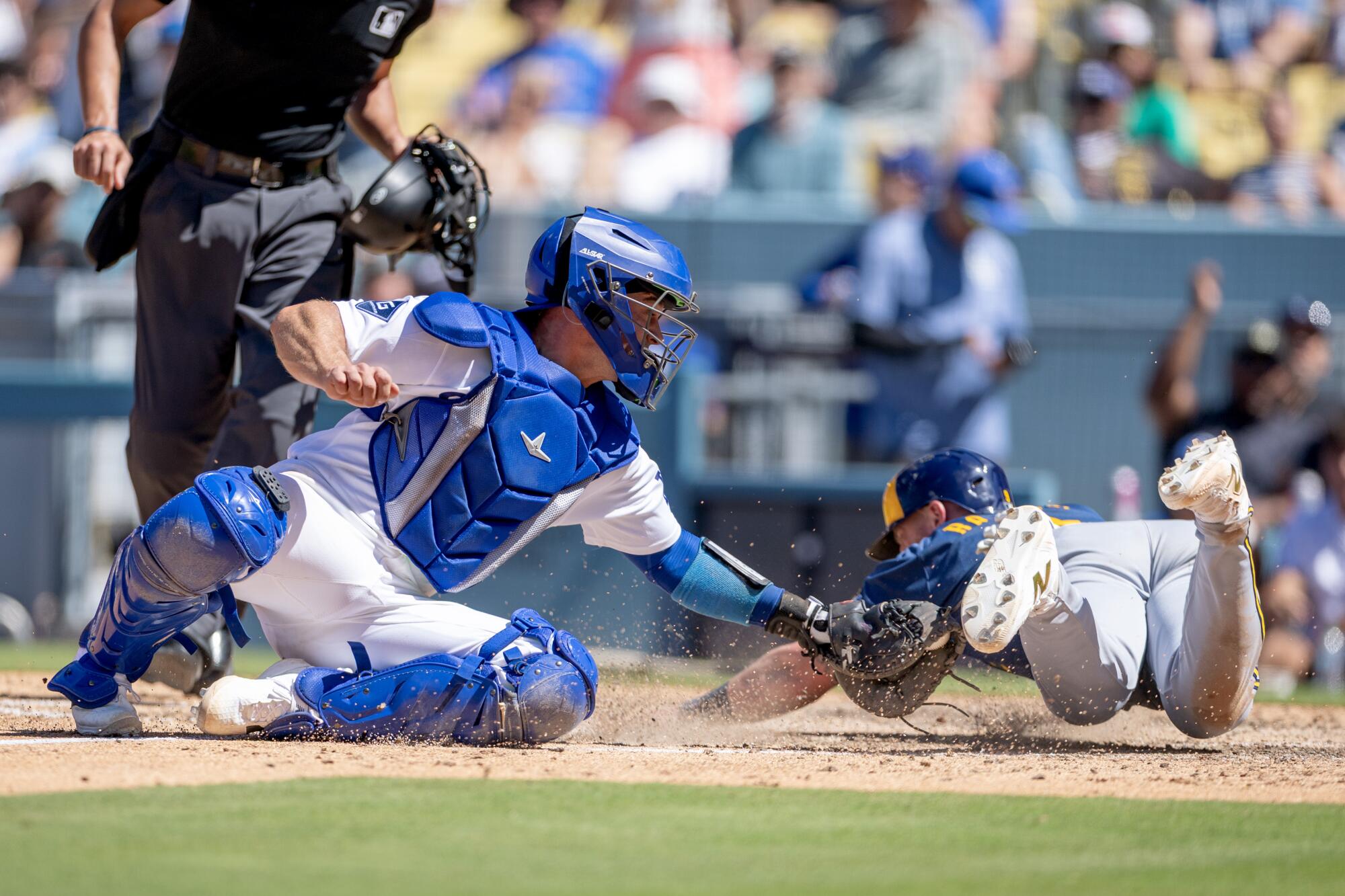 Milwaukee's Jake Bauers beats a tag attempt by Dodgers catcher Ben Rortvedt to score in the seventh inning Sunday.