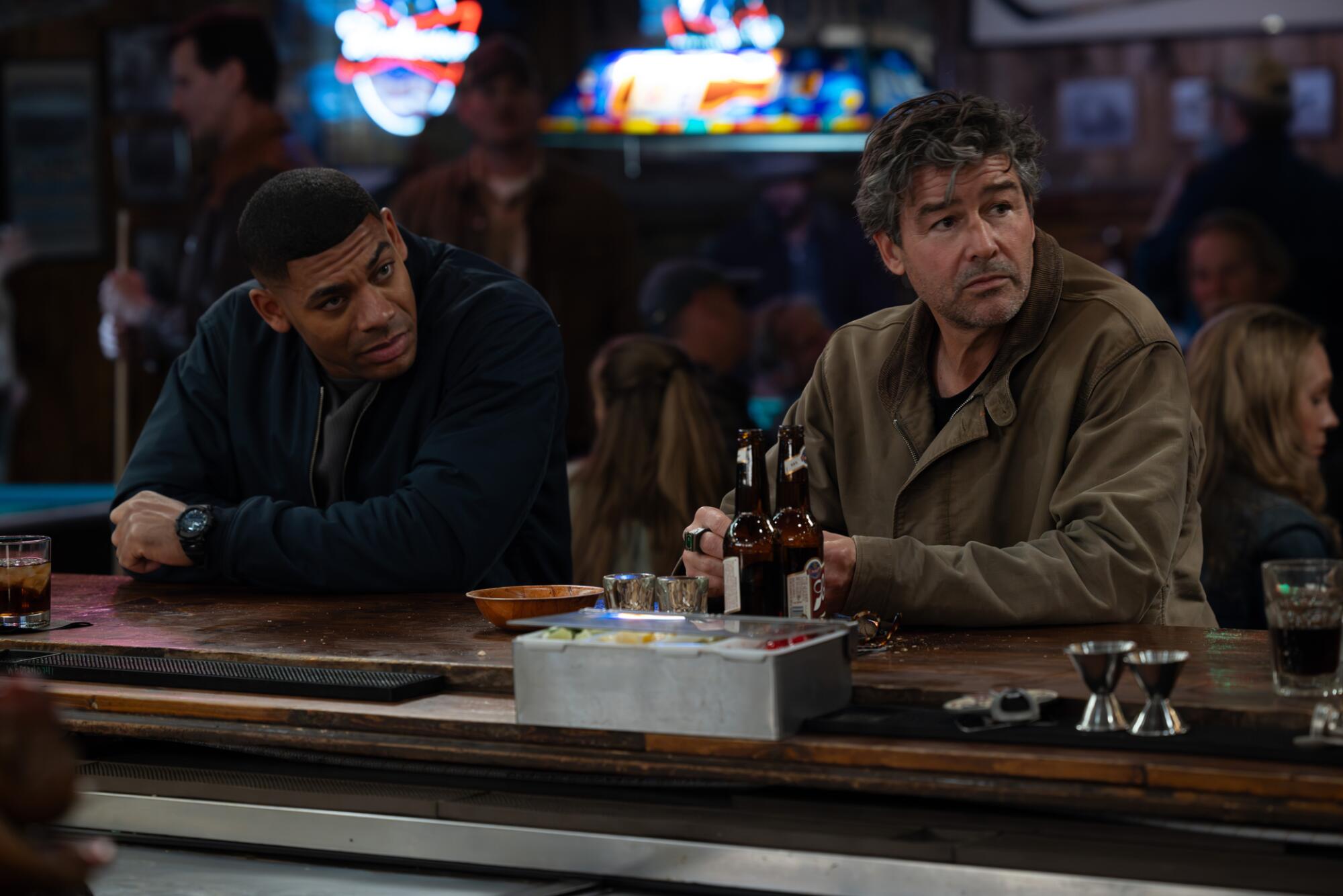 two men sitting at a bar