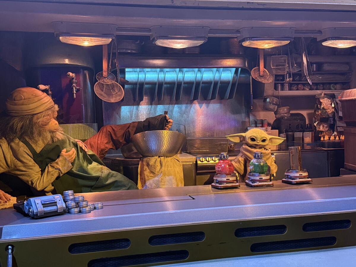 Two robotic space aliens in a food truck-like environment. 