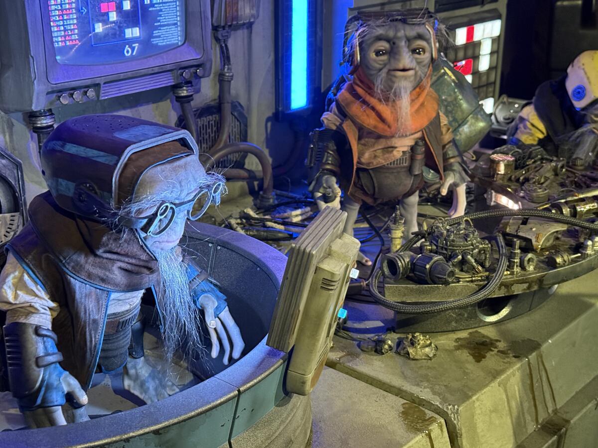 Two tiny robotic figures that serve as alien mechanics. 