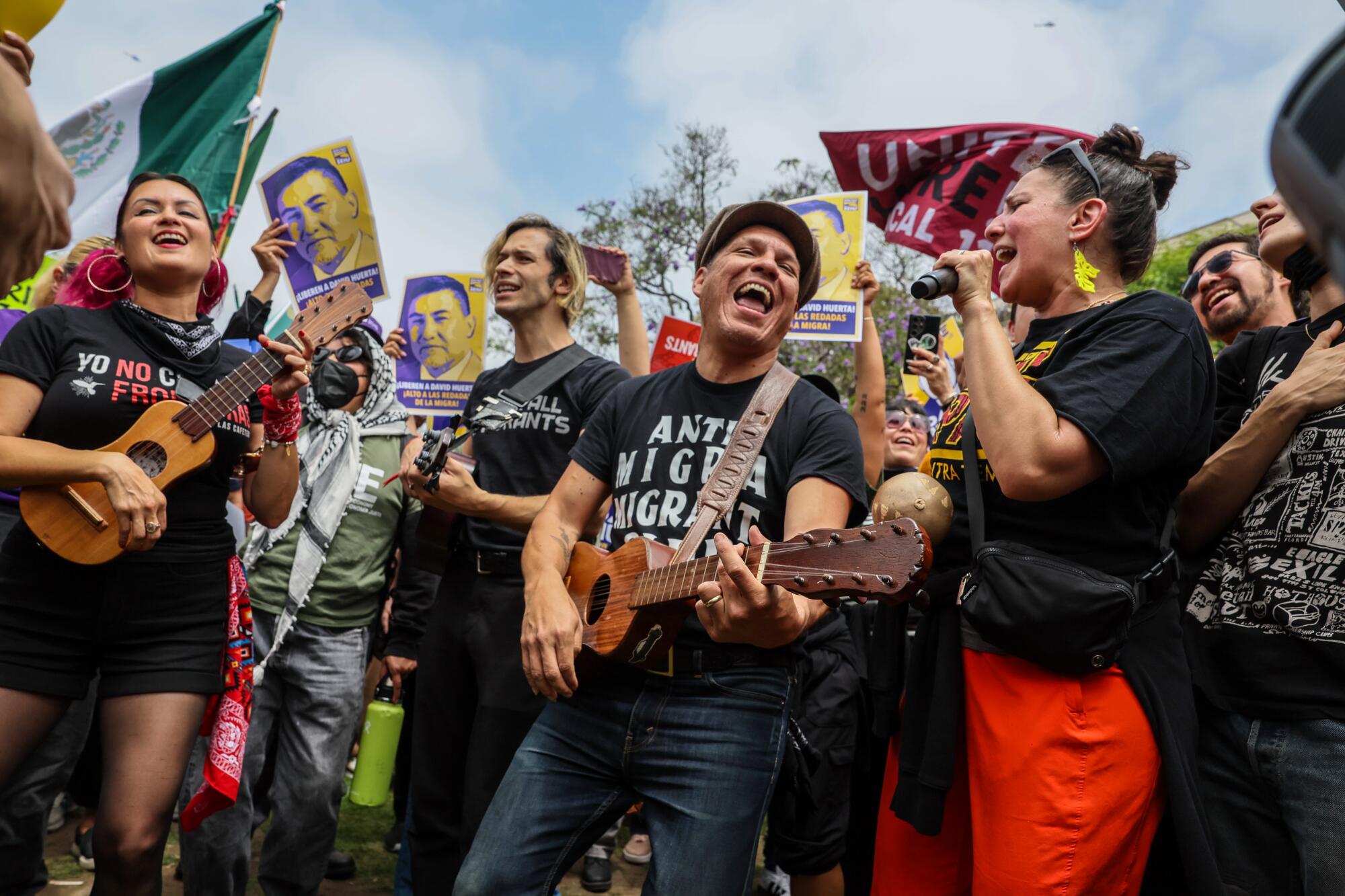 Members of Las Cafeteras lead supporters in song at a rally in support of union leader David Huerta at Grand Park.