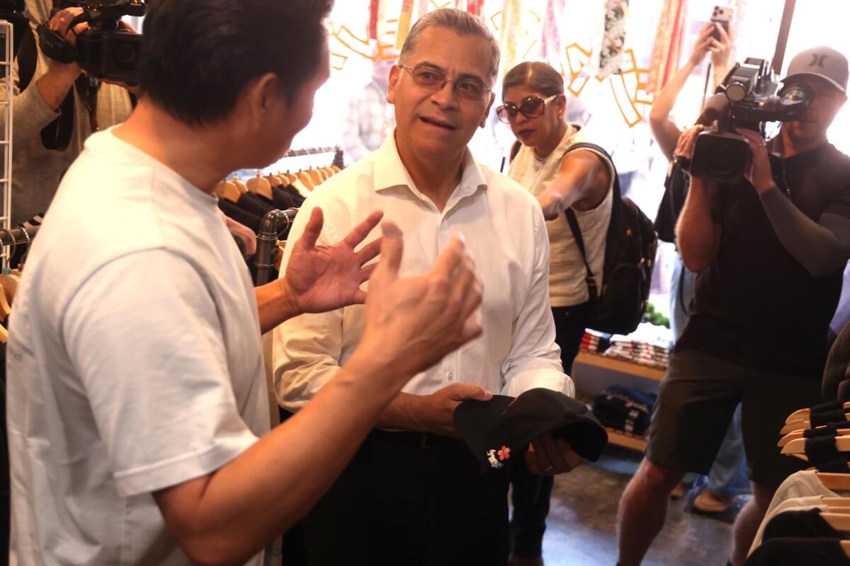 Sec. Xavier Becerra, center, listens to Roy Kuroyawagi, owner of Japangeles.