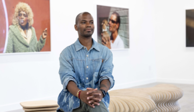 A man stands in front of a gallery wall.