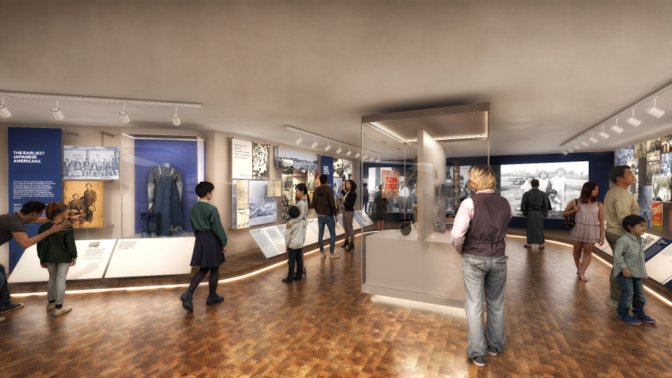 A museum gallery with more than a dozen visitors gazing at displays about Japanese American history.