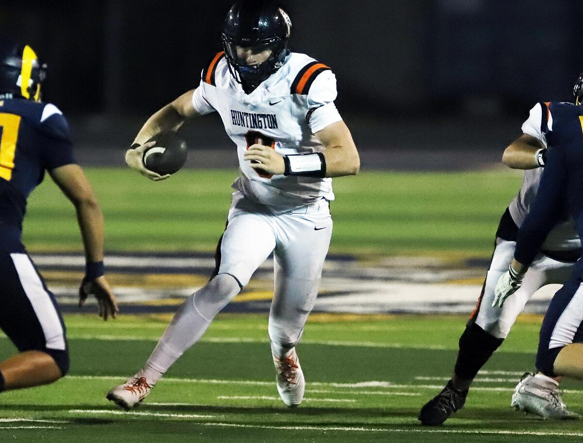 Huntington Beach quarterback Brady Edmunds (9) runs through the middle against Millikan in a nonleague football opener.