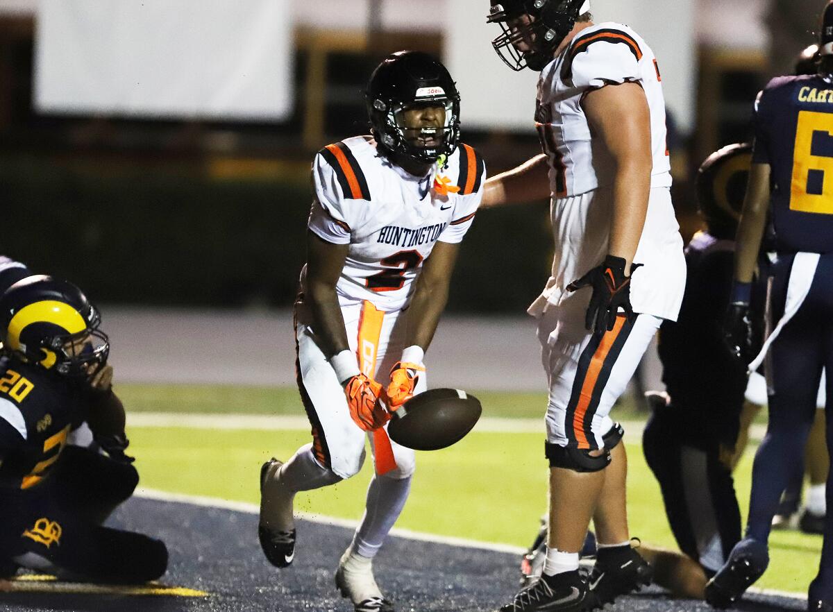 Huntington Beach's Dylin Bruce (2) yells out in celebration after scoring a touchdown against Millikan.