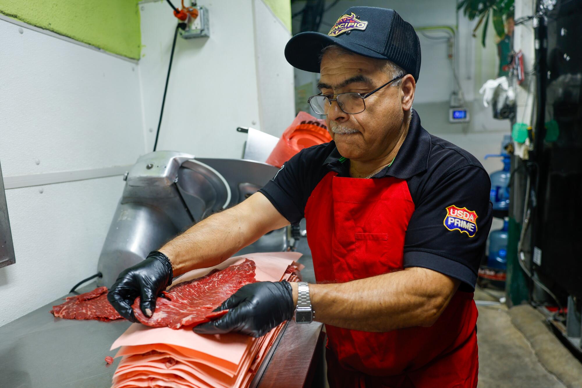 Butcher Ramiro Bautista lays down a cut of ranchera meat