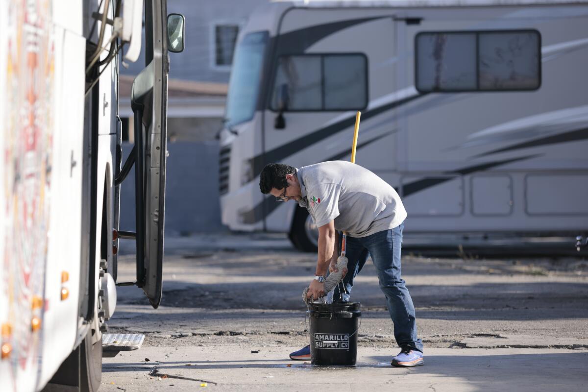 An employee washes the windows of a bus