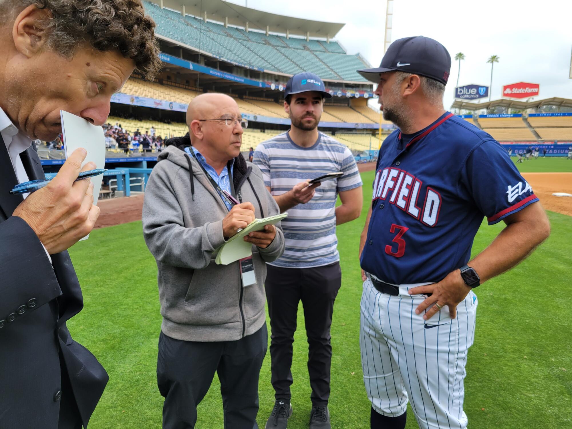Eric Sondheimer interviews Garfield coach Ruben Torres after a City Section championship game at Dodger Stadium in 2022.