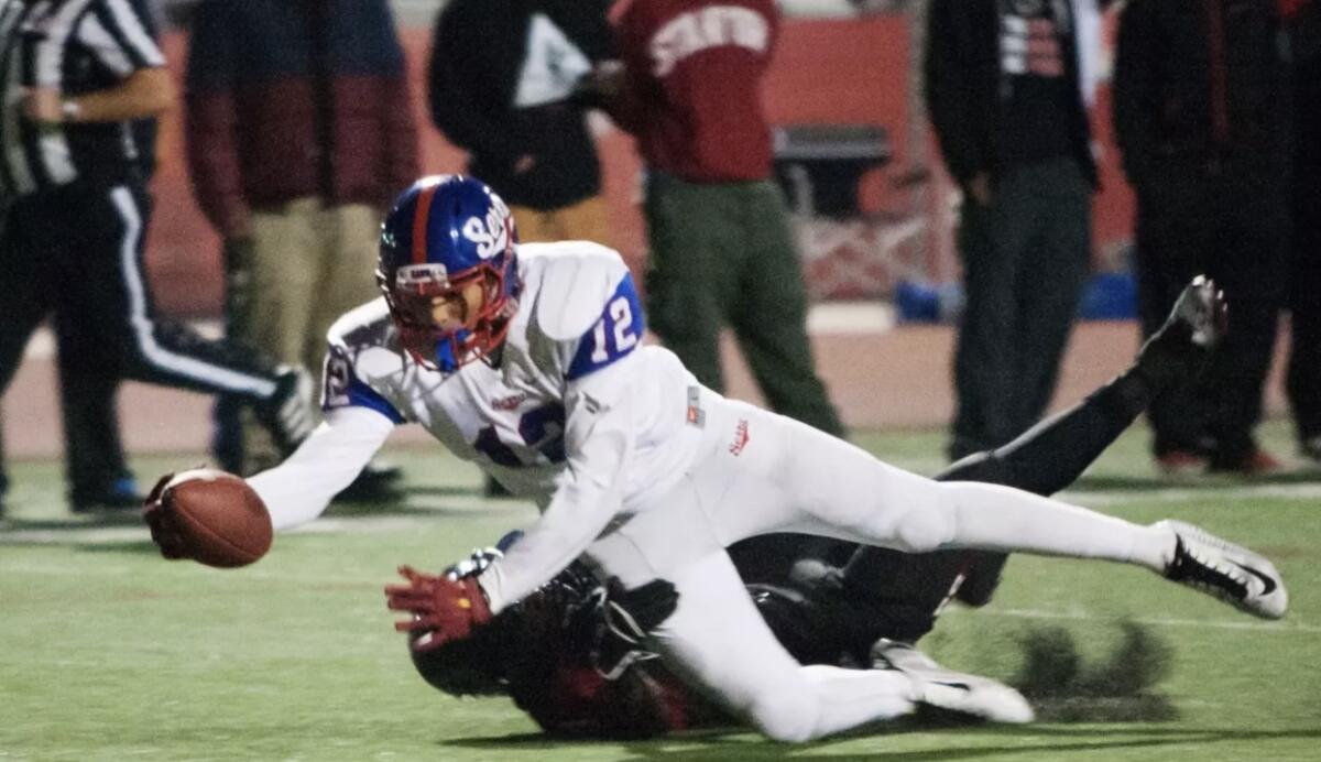 In 2014, Caleb Wilson of Gardena Serra tries to make a catch in a playoff game won by Corona Centennial 68-64.