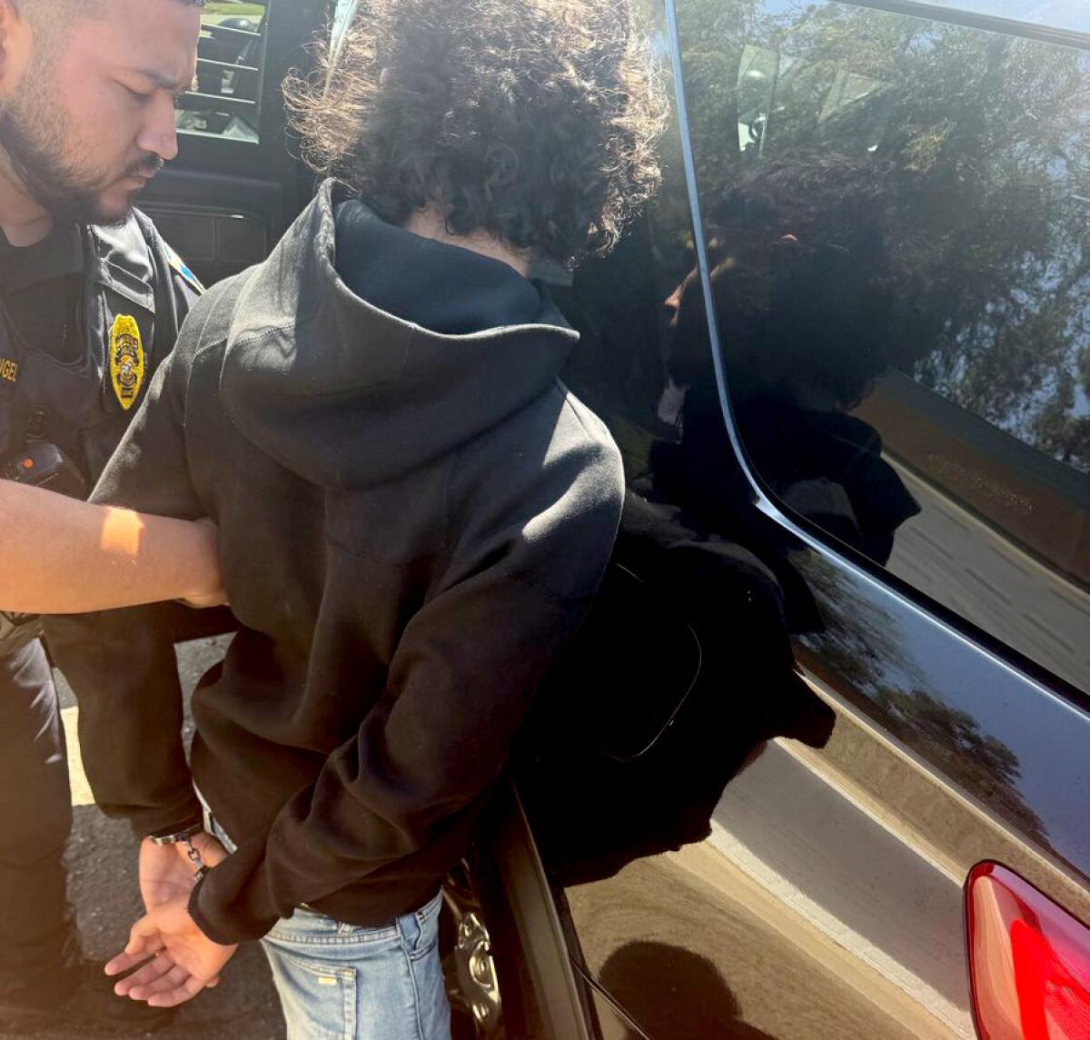 Police handcuff a teenager.