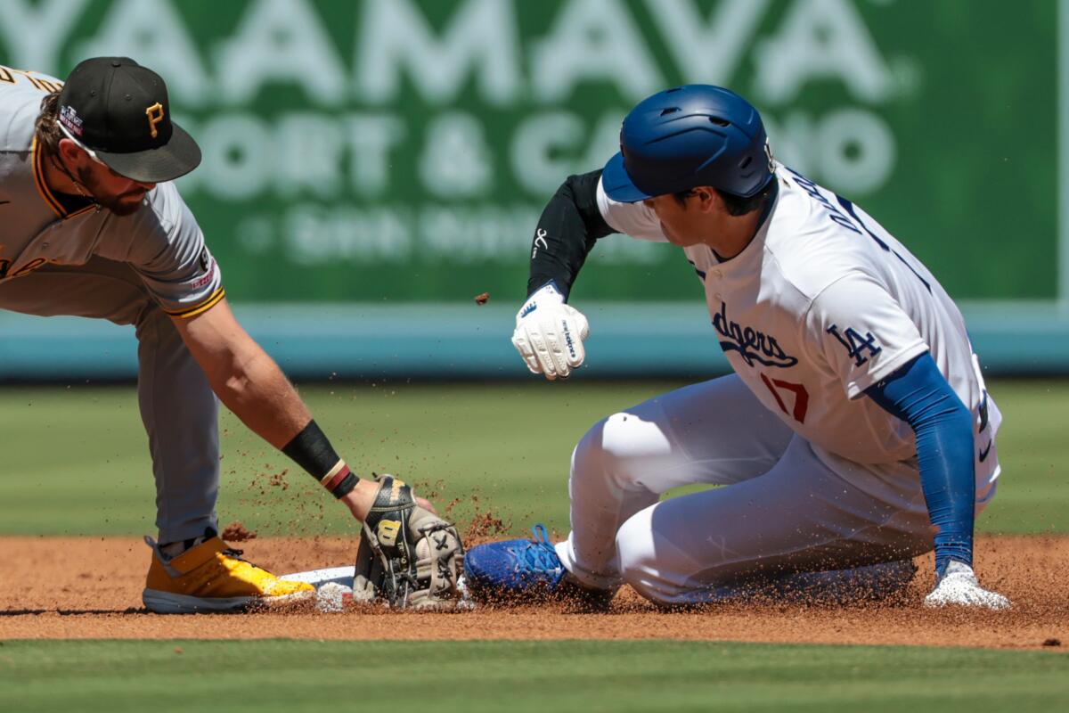 Dodgers designated hitter Shohei Ohtani beats the tag of Pittsburgh Pirates shortstop Jared Triolo to steal second base.