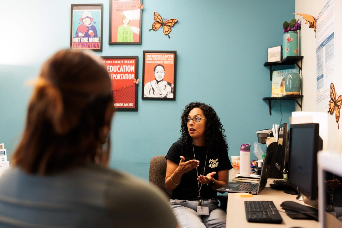 A female college counselor meets with a student.