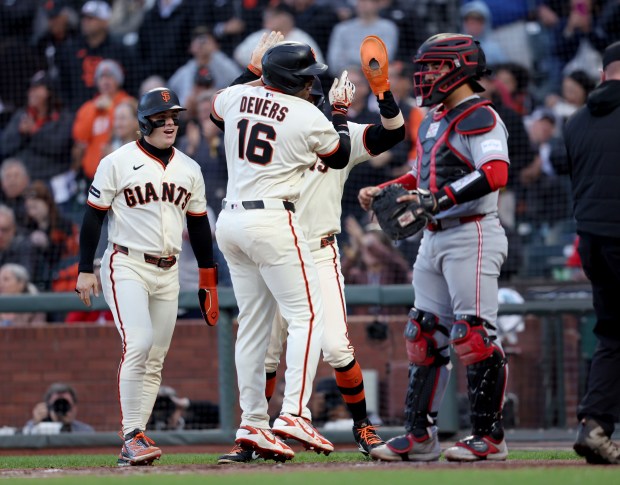 San Francisco Giants' Rafael Devers #16 celebrates with teammates Drew Gilbert #0 and Christian Koss #50 after hitting a three-run RBI home run off Cincinnati Reds starting pitcher Chase Burns #26 in the second inning of their MLB game at Oracle Park in San Francisco, Calif., on Monday, August 24, 2026. (Jane Tyska/Bay Area News Group)