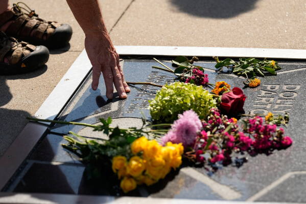 Michael Reynolds visits Dolly Parton's star on the Music City Walk of Fame outside the Country Music Hall of Fame on Tuesday, Aug. 25, 2026, in Nashville, Tenn. (AP Photo/George Walker IV)