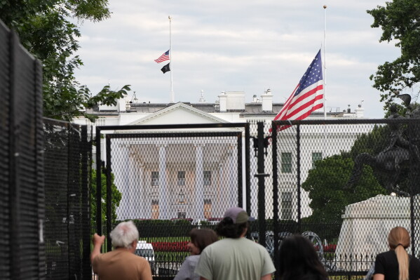 Flags fly at half staff in honor of Dolly Parton, Tuesday, Aug. 25, 2026, in Washington, at the White House. (AP Photo/Alex Brandon)