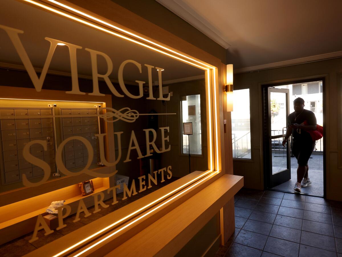 A tenant walks into the lobby at the Virgil Square Apartments.