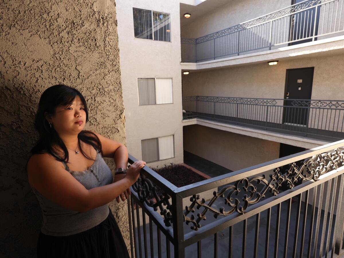 Tenant Angie Jahja stands on a balcony 
