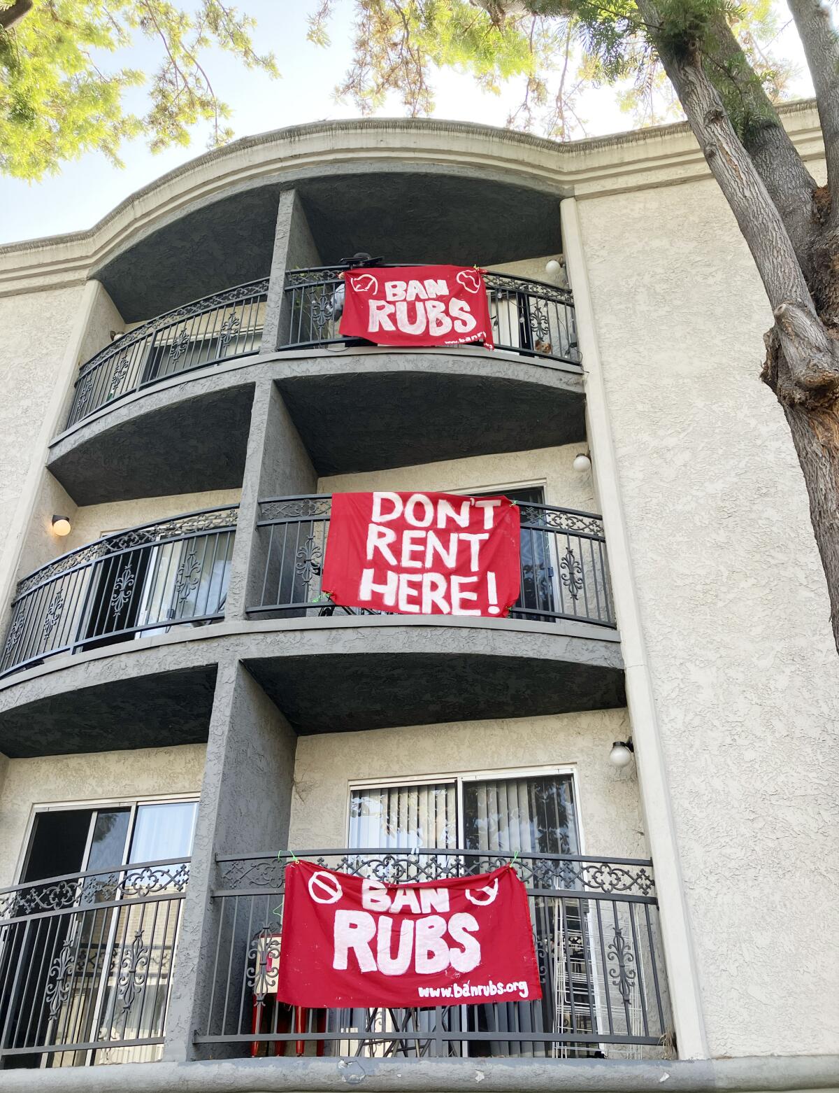 Large red signs protesting RUBS hang on balconies