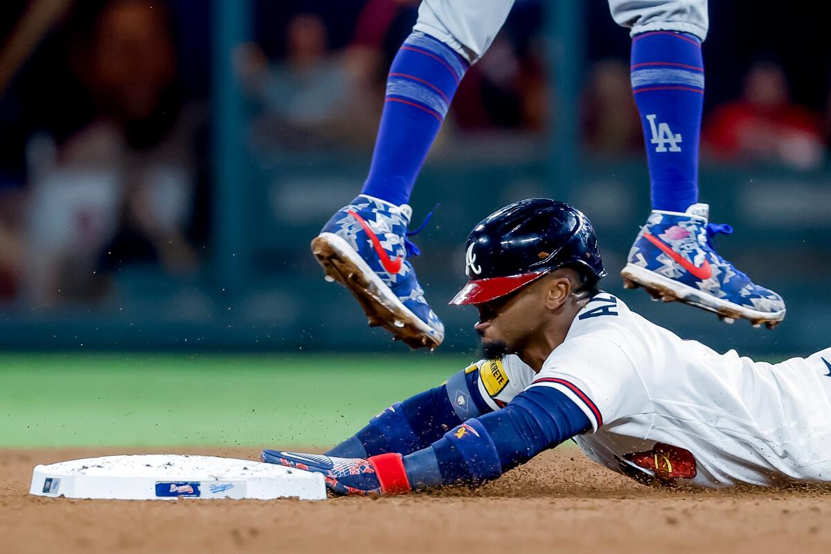 Ozzie Albies steals second base as Dodgers shortstop Mookie Betts leaps for the ball in the fourth inning Wednesday.