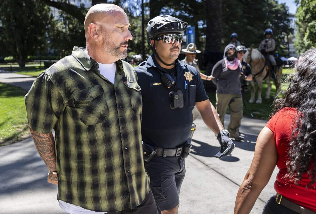 Men involved in an altercation are detained by the California Highway Patrol during Nick Shirley's appearance at a Republican news conference at the state Capitol on Wednesday.