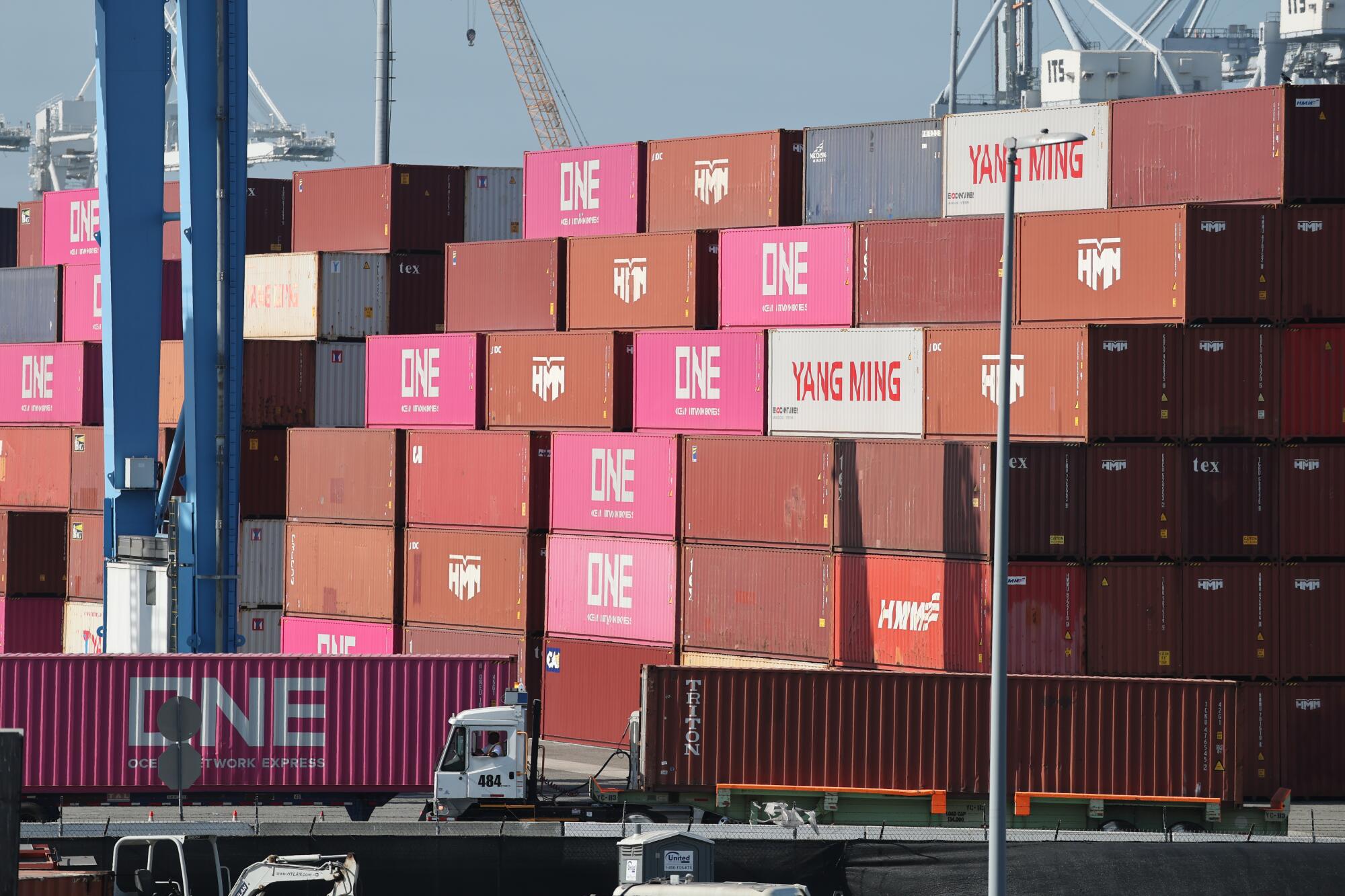 Trucks move goods in a shipping container at the Port of Long Beach.