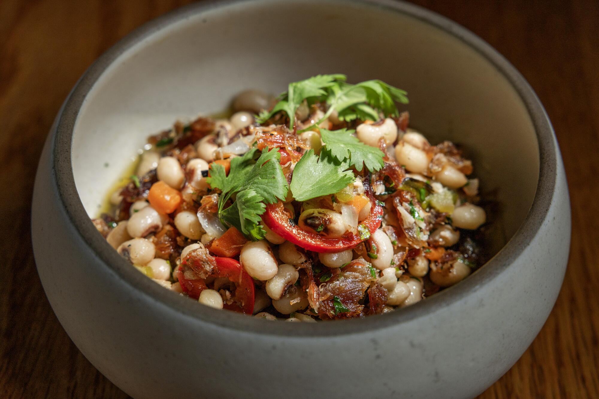 Black-eyed pea salad with crispy ham hock, tossed with fresh chiles, charred scallions, cilantro and lime juice.
