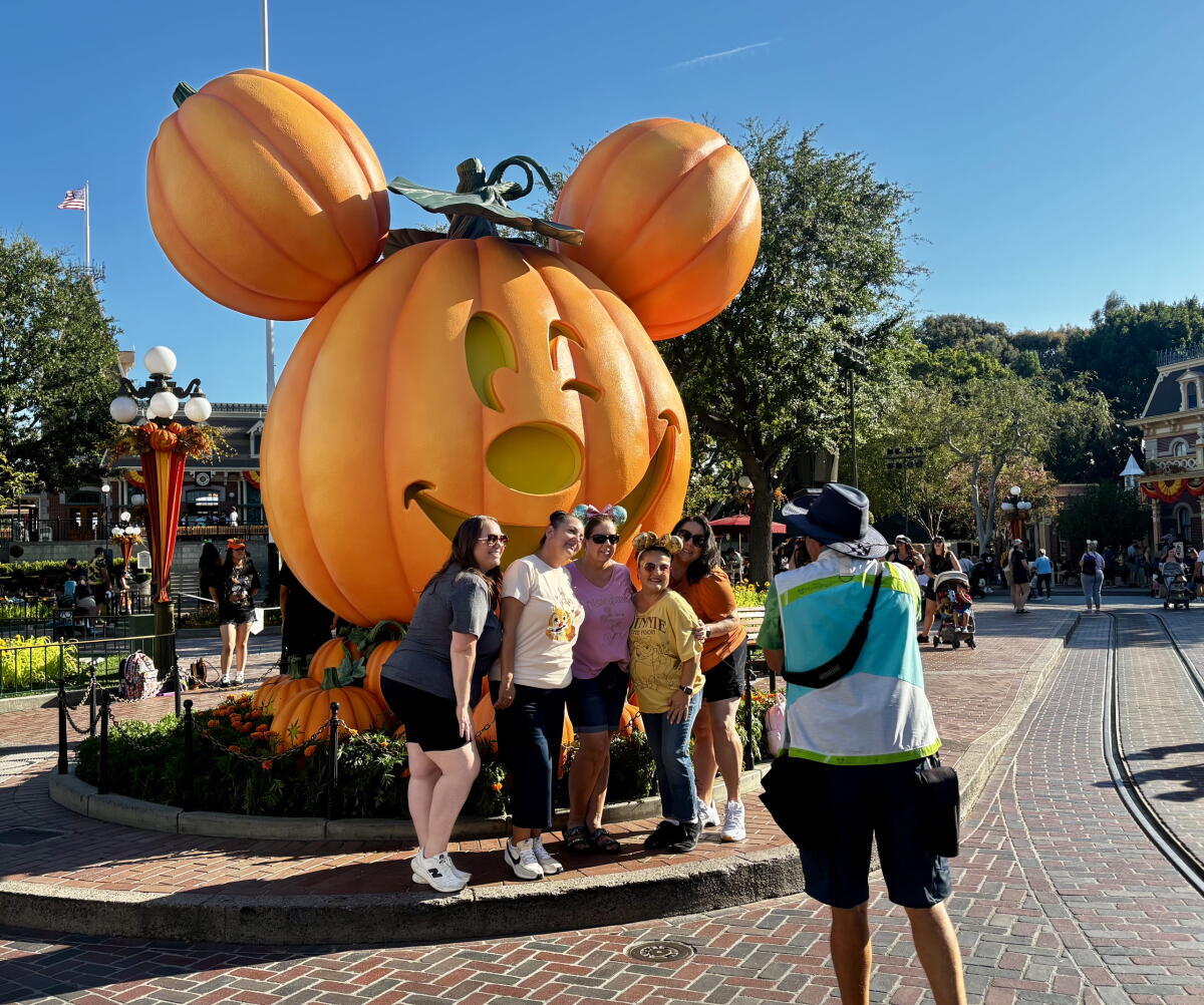 Park visitors pose in front of the Mickey pumpkin at Main Street, U.S.A. at Disneyland.