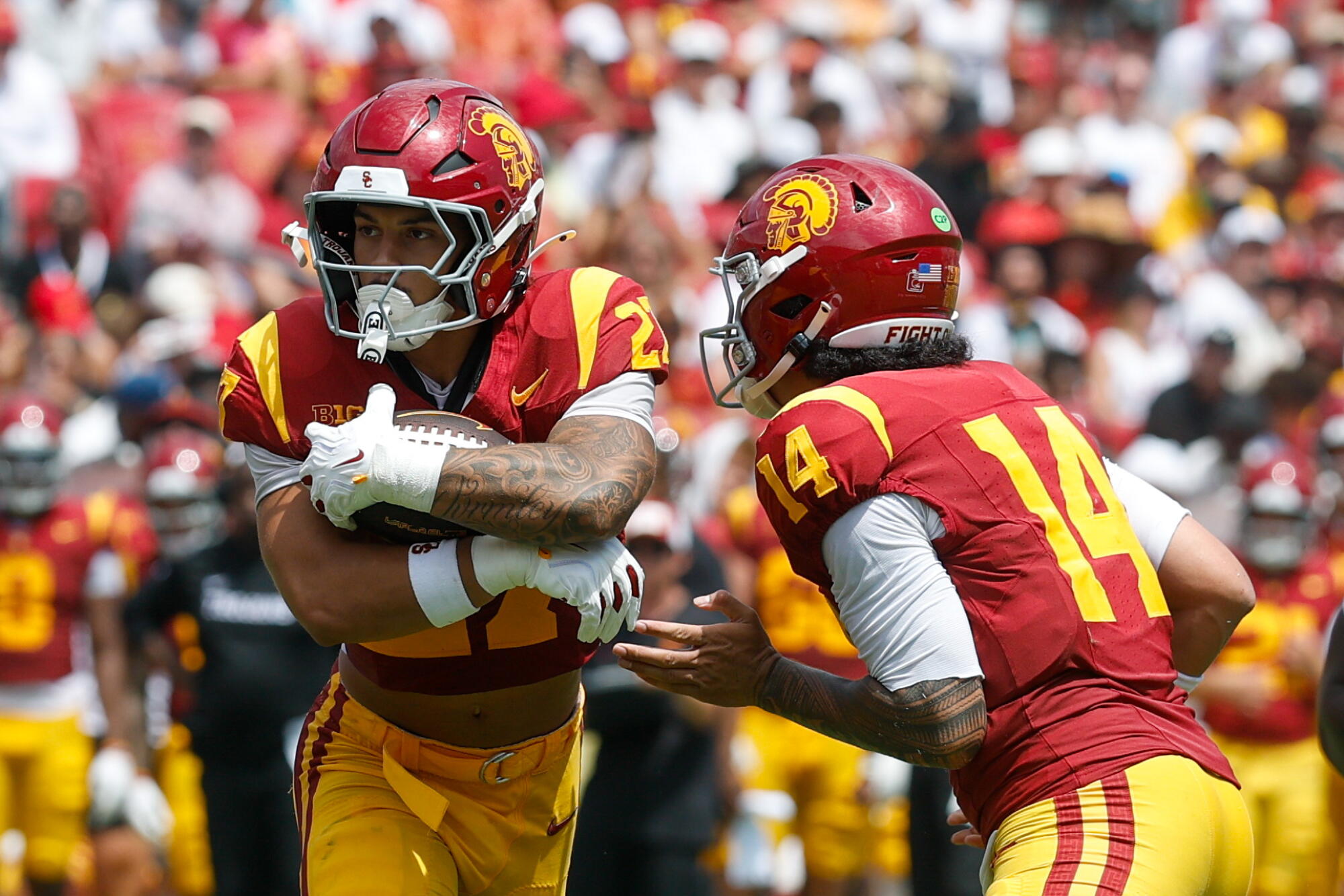 USC quarterback Jayden Maiava, right, hands off the ball to running back Riley Wormley.