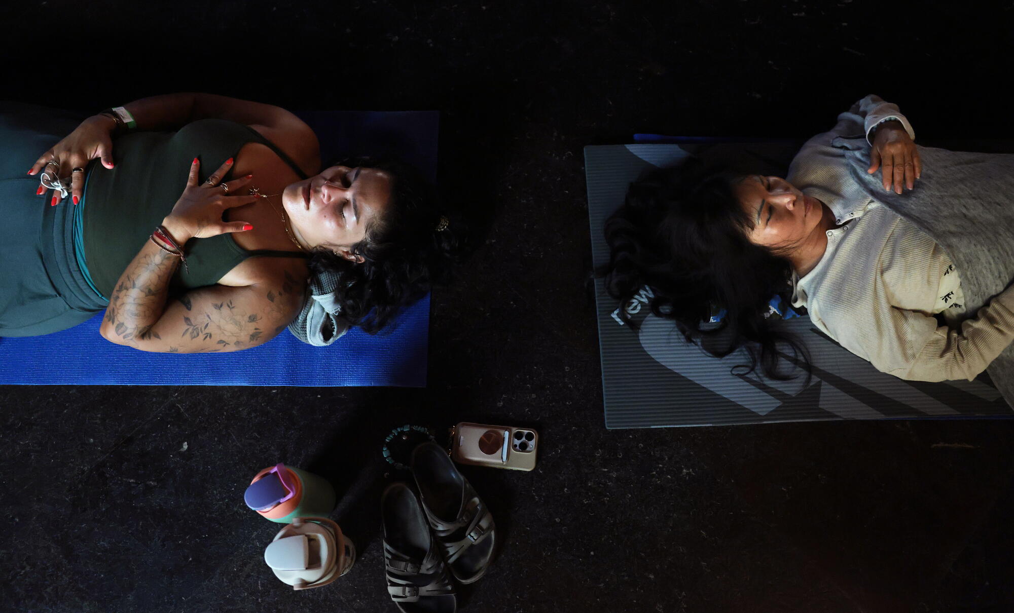 Two women lay on yoga mats