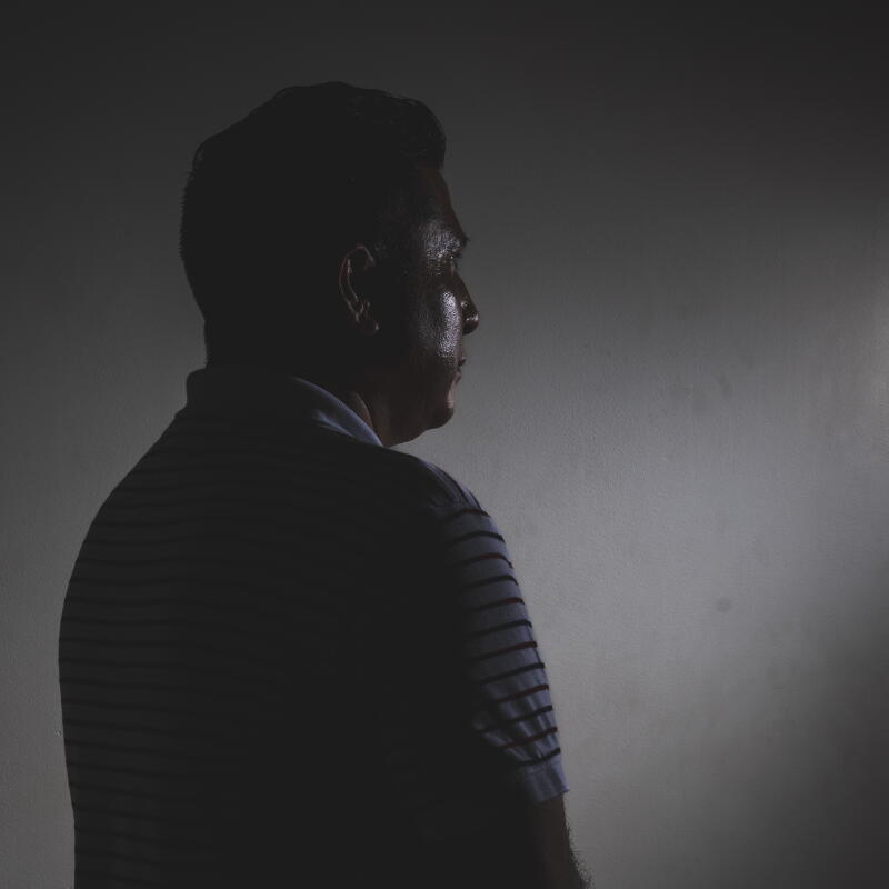 A man stands for an anonymous portrait