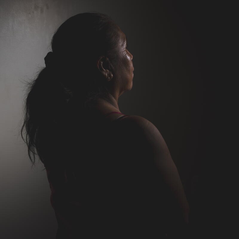 A woman stands for an anonymous portrait.