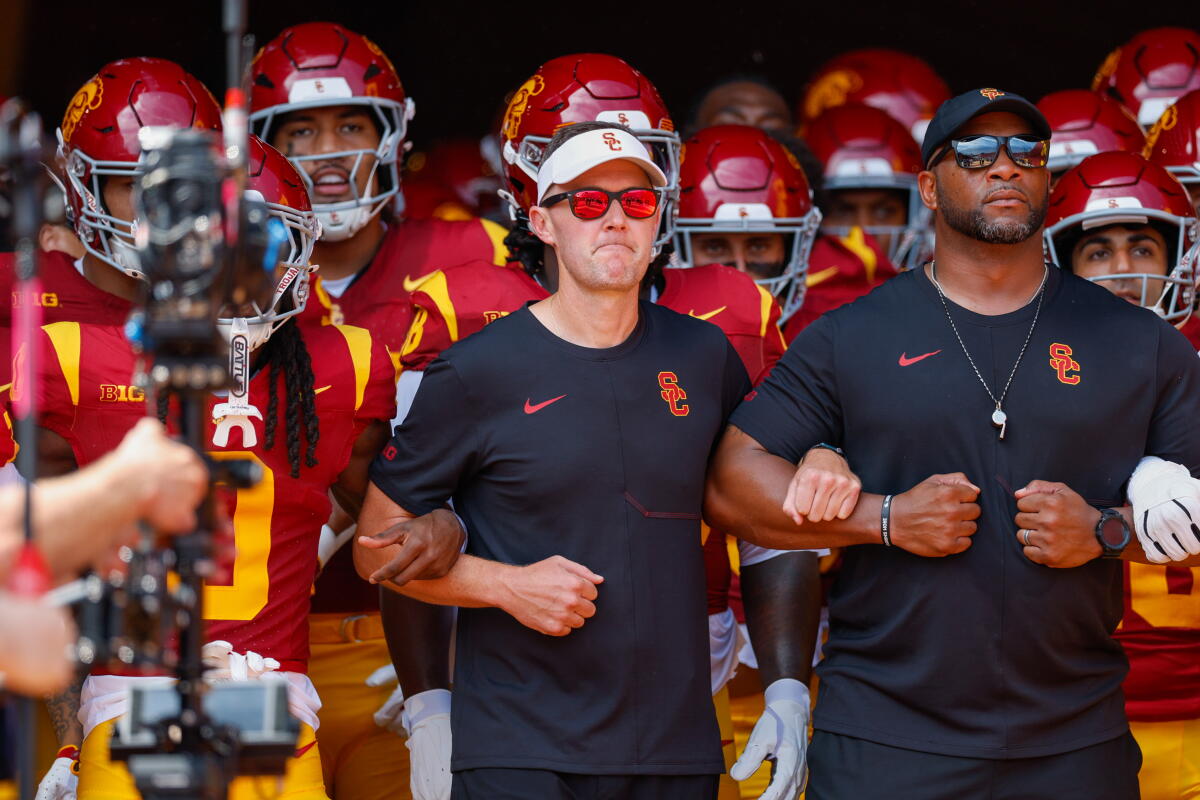 USC head coach Lincoln Riley, middle, leads his team onto the field prior the start of a football game.