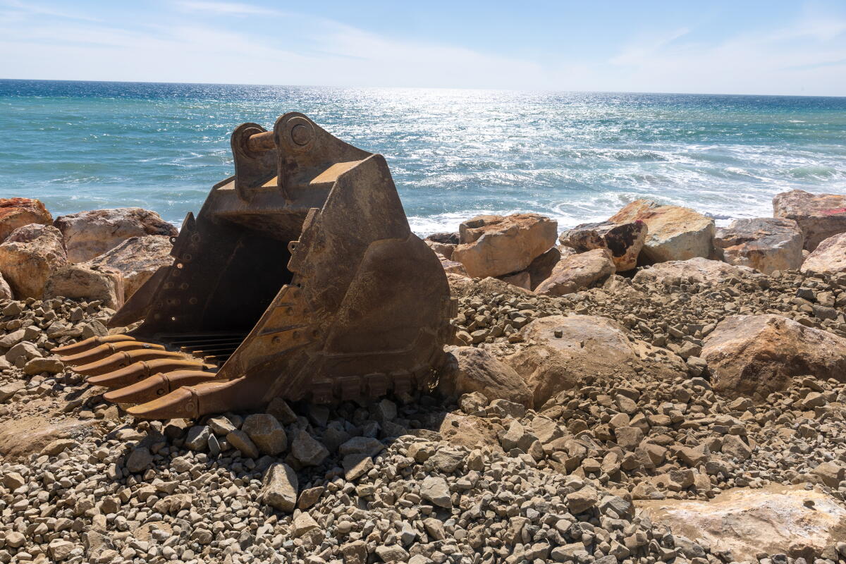 a construction shovel on the beach
