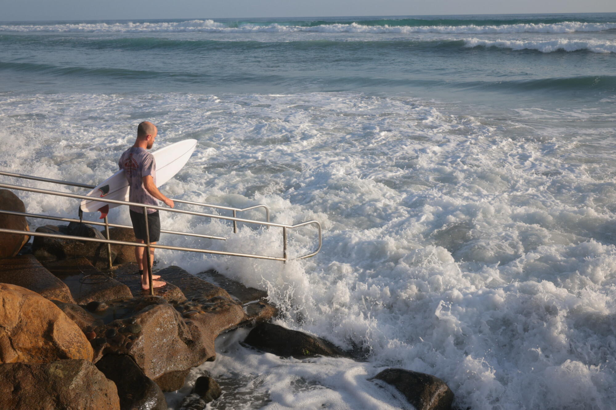 A surfer looks out at the ocean