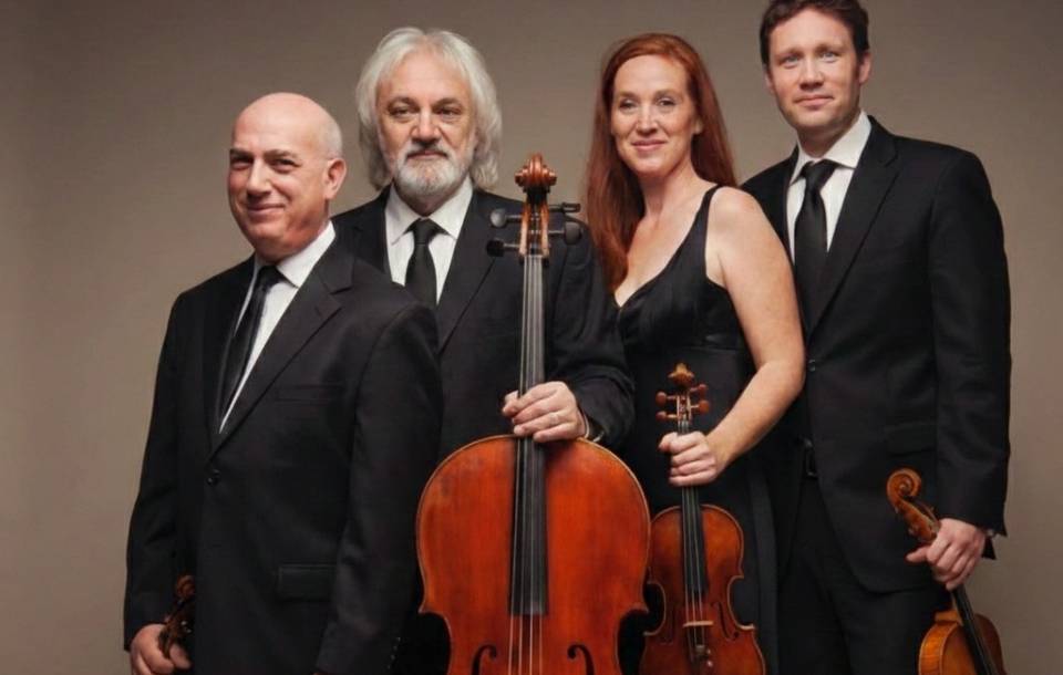 three male and one female string players in concert attire hold instruments